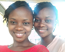 Two identical twin girls smiling.