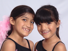 A picture of two young twin girls smiling.