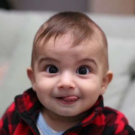 Face of a baby sticking his tongue out